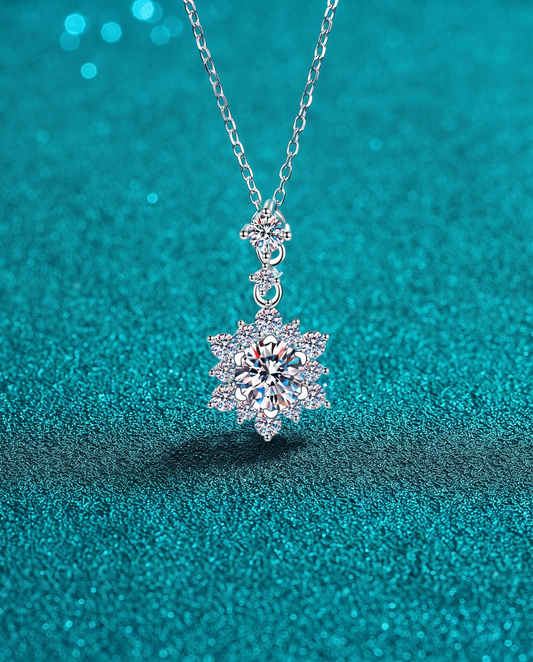 Silver necklace with a snowflake-shaped pendant set with stones, on a chain