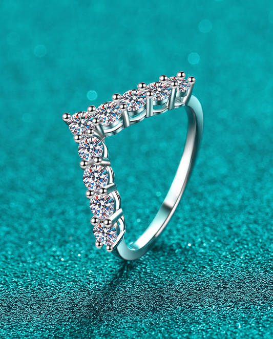 Silver V-shape ring with a row of round stones along the band