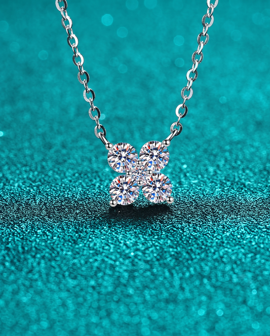 Silver pendant necklace with four moissanite stones in a clover arrangement on a chain